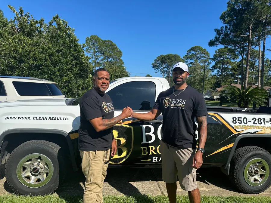 The two Boss Brothers shaking hands in front of the wrapped truck