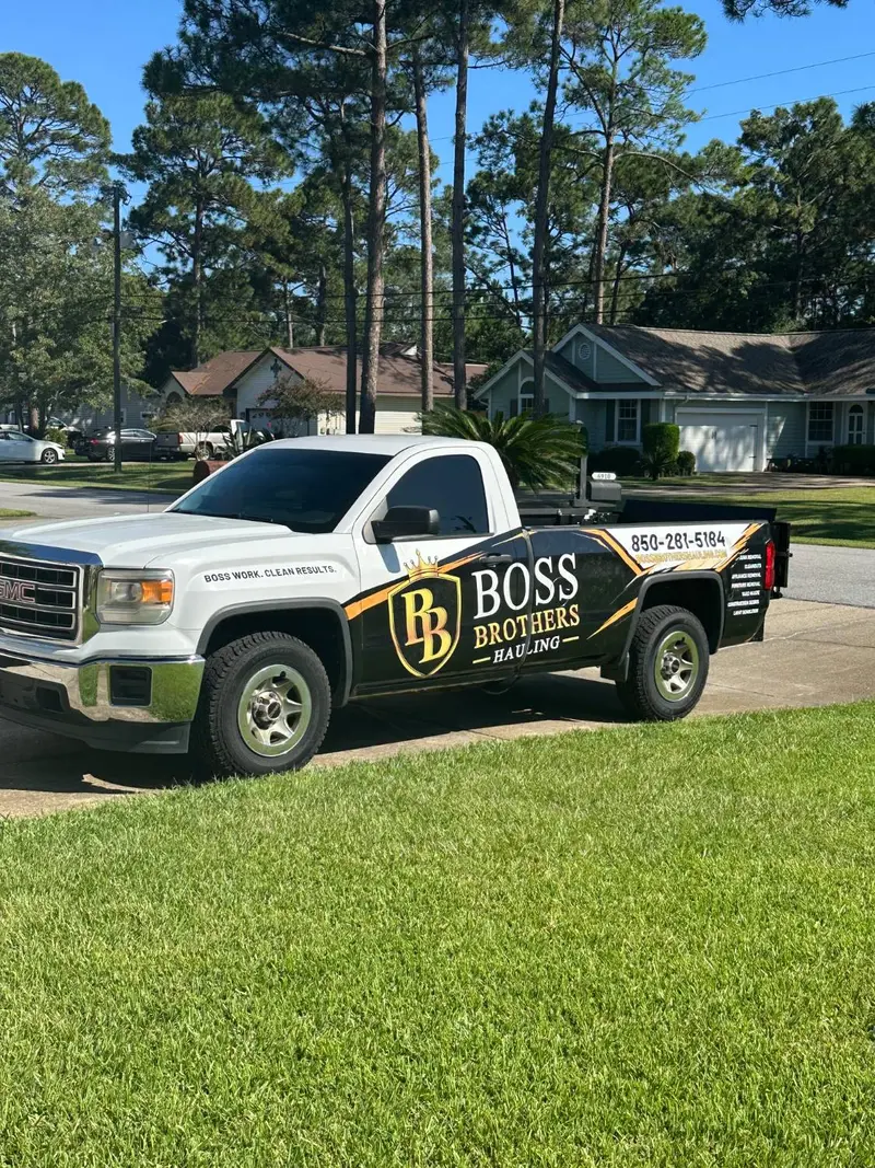 The wrapped Boss Brothers Hauling pickup parked in a driveway